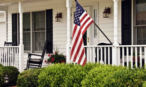 House with a front porch displaying an American flag.