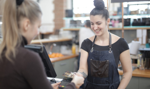 Woman paying with a debit card at a cafe.