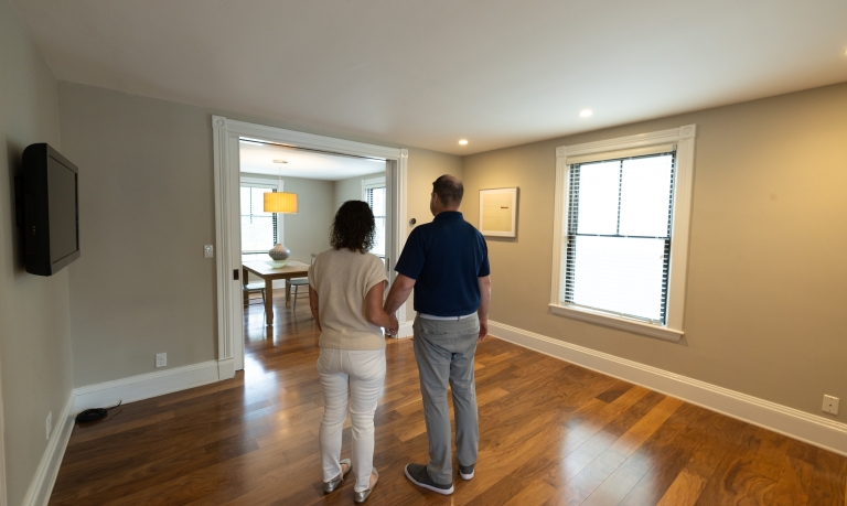 A couple walking through a new, empty house on the market for sale.