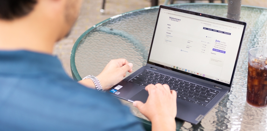 Man checking his business bank accounts on WSB online while sitting at a cafe.