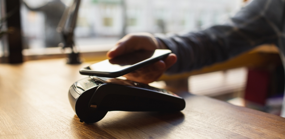 Customer making a payment using his mobile wallet on his phone.