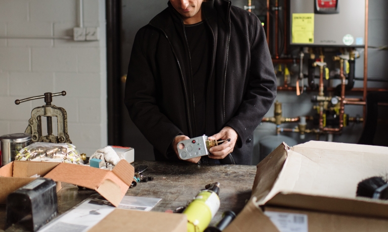 Business owner checking his electrical equipment at his shop.