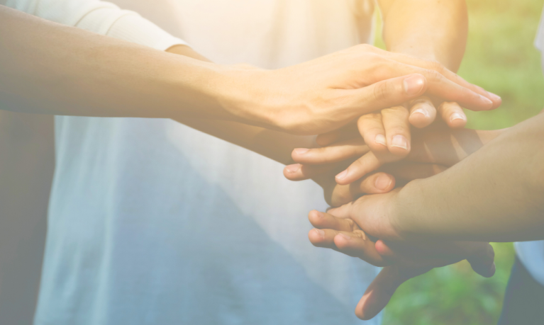 Hands stacked on top of each other in sign of solidarity and teamwork.