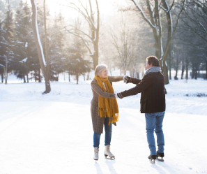 Older couple skating in a forest.