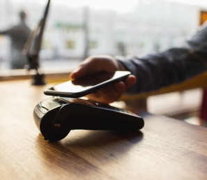 Customer making a payment using his mobile wallet on his phone.