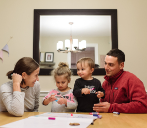 Young family coloring at the family table.