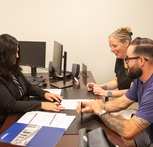 A Loan Officer meeting with a couple and going through their documents.